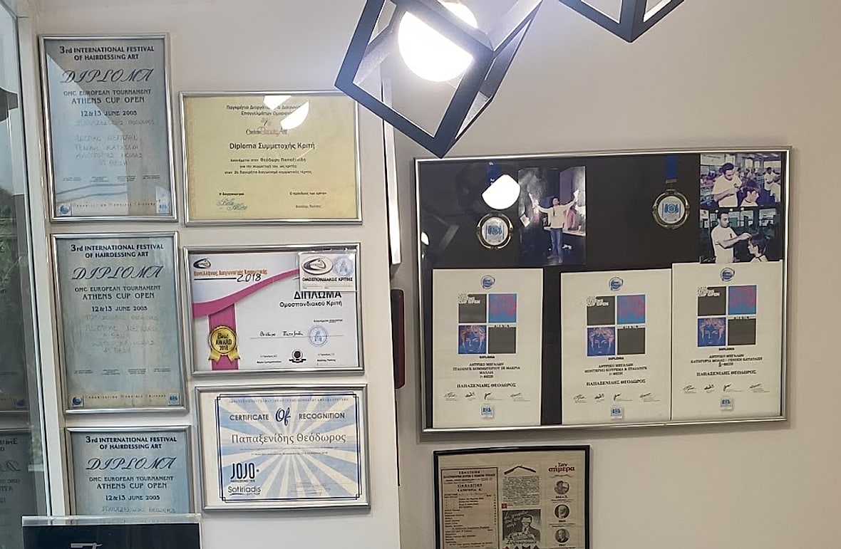 Ο τοίχος με τα διπλώματα και τα μετάλλια στην υποδοχή του μαγαζιού
